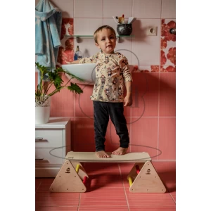 Bērns vannasistabā stāv uz multifunkcionālā balansa trenažiera