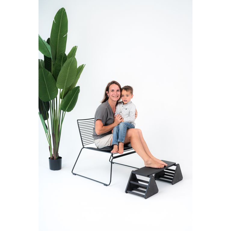 Balance constructor, black. Board in top position. Mum and baby use the balance constructor as a footrest.