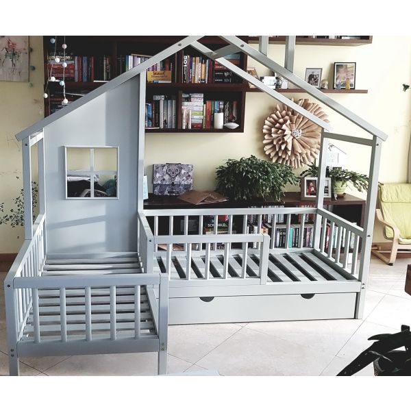 Stūra gulta ar lodziņu pelēkā krāsā. Divguļamā bērnu gulta ar2 lādēm zem labās puses guļvietas un dekoratīvu sienu ar lodziņu.