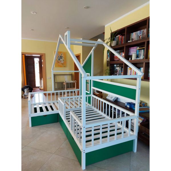 Stūra gulta ar logu un plauktiem, kreisais stūris, baltā krāsā ar zaļiem akcentiem. Gulta diviem bērniem, divvietīga bērnu gulta. Foto no sāna.