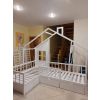 Stūra gulta ar lodziņu baltā krāsā. Divguļamā bērnu gulta ar2 lādēm zem labās puses guļvietas un dekoratīvu sienu ar lodziņu.